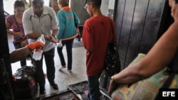 Pasajeros pasan por un control sanitario en la terminal de ómnibus de La Habana tras registrarse un brote de cólera en la isla.