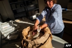 Una empleada del gobierno alemán tras la caída del Muro de Berlín recupera documentos de bolsas marcadas “para destruir” en lo que fuera la sede de la STASI (Foto: John MacDougall/AFP).