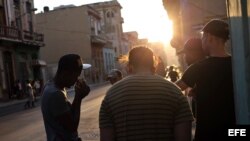Varios jóvenes conversan en una esquina de La Habana. 