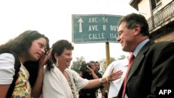 Magalys de Armas, esposa del opositor Vladimiro Roca, y su hija saludan a Michael Georges Kozak(R), en el Tribunal Municipal de Marianao. AFP/ADALBERTO ROQUE