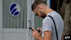 Un cubano se conecta a internet desde su celular en un punto WIFI de La Habana.