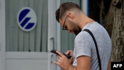 Un cubano se conecta a internet desde su celular en un punto WIFI de La Habana. (AFP).