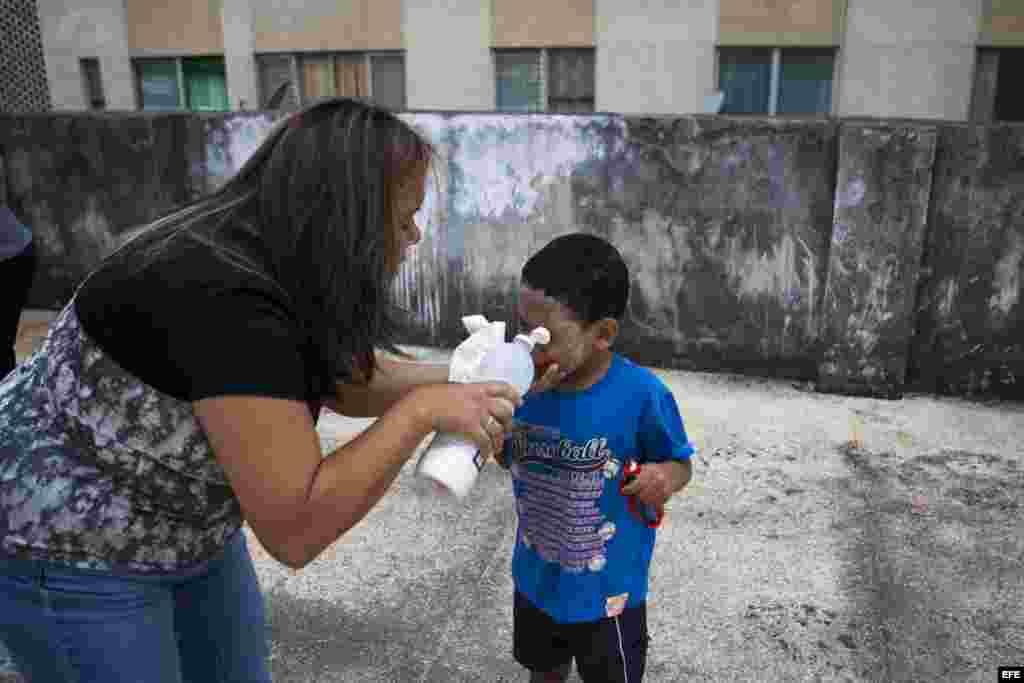 Una mujer atiende a un niño afectado por gases lacrimógenos hoy, viernes 7 de marzo de 2014, en la Plaza Altamira de Caracas (Venezuela).