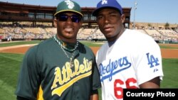 Yoenis Céspedes (i) se encuentra con Yasiel Puig durante un partido de entrenamiento en Phoenix, Arizona.