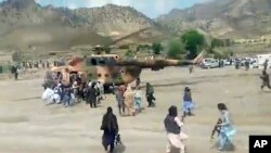 Talibanes custodian un helicóptero gubernamental para trasladar a heridos en el sismo, en Gayan, provincia afgana de Paktika. (Agencia noticiosa estatal Bakhtar vía AP)