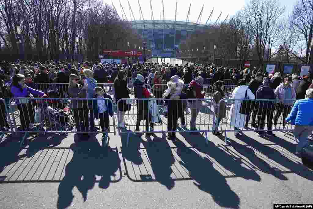 Las personas esperan en una cola en el Estadio Nacional de Varsovia en Polonia para poder aplicar por un número de Identificación polaca que los dejará trabajar, tener servicios médicos gratuitos y educación. Foto: AP/Czarek Sokolowski.