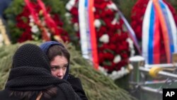 Una mujer conforta a la hija del opositor ruso Boris Nemtsov durante su entierro, el 3 de marzod e 2015, en el cementerio Troekurovskoye de Moscú. (AP/Denis Tyrin)