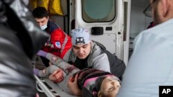 Rescatistas ucranianos socorren a una menor que fue herida en Mariupol, al este de Ucrania. 