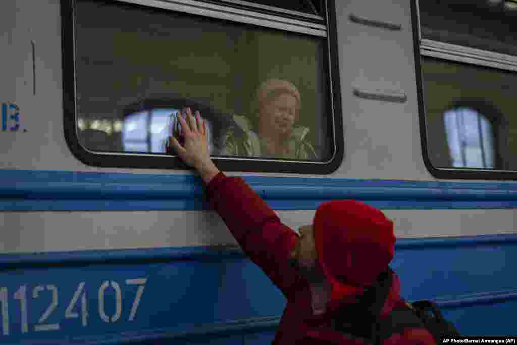 Ucranianos desplazados en un tren hacia Polonia se despiden de familiares en Lviv, Ucrania. Foto: AP/Bernat Armangue.