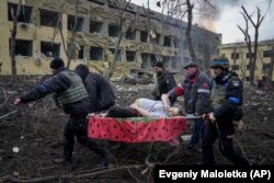 Personal de servicios de emergencia transportan en camilla a una embarazada herida por los bombardeos rusos en Mariúpol, el 9 de marzo. El bebé nació muerto y media hora después falleció la madre.