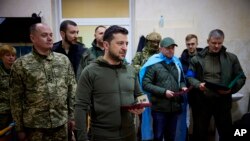El presidente de Ucrania Volodymyr Zelensky (centro) entrega una medalla a un soldado herido, durante su visita a un hospital de Kyiv, el domingo pasado.