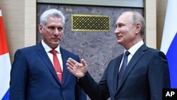 El presidente ruso Vladimir Putin señala al gobernante cubano Miguel Díaz Canel, en la visita de este a Moscú, en octubre de 2019. (Alexander Nemenov/Pool vía AP)