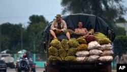 Trabajadores transportan viandas en un camión. Foto Archivo AP Photo/Ramon Espinosa