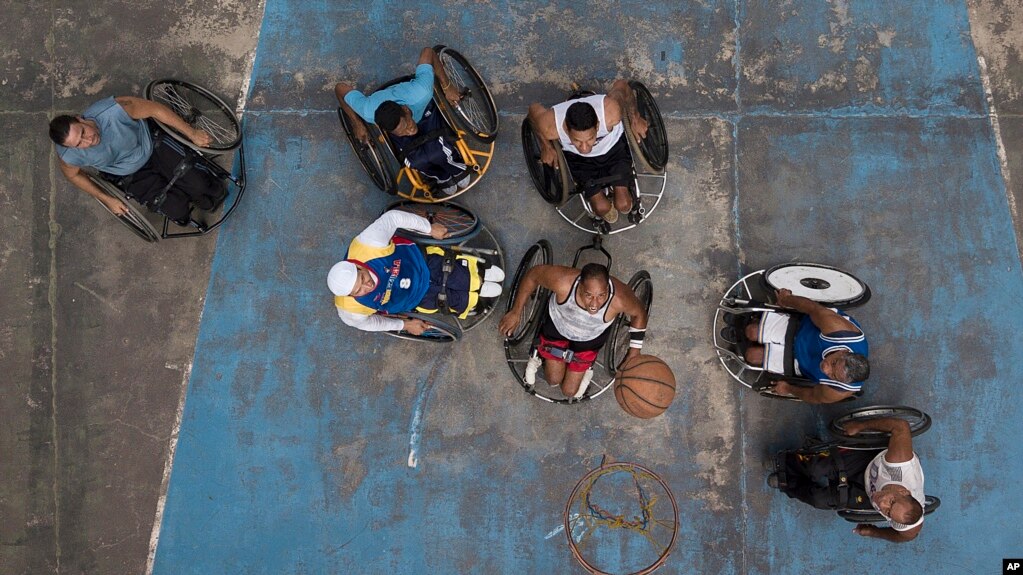 Manuel Mendoza juega baloncesto con sus amigos en silla de ruedas en una cancha pública en el barrio Artigas de Caracas, el 24 de octubre de 2020.