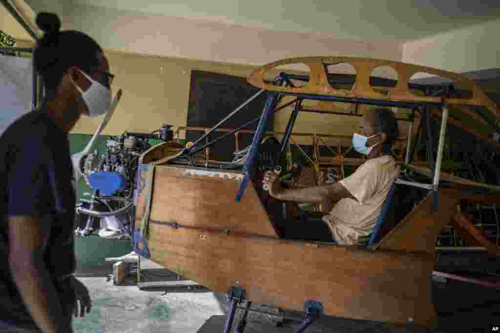 Adolfo Rivera posa en el avión que está haciendo en el garaje de su edificio de apartamentos en La Habana, Cuba, el viernes 19 de febrero de 2021. (AP Foto/Ramón Espinosa)