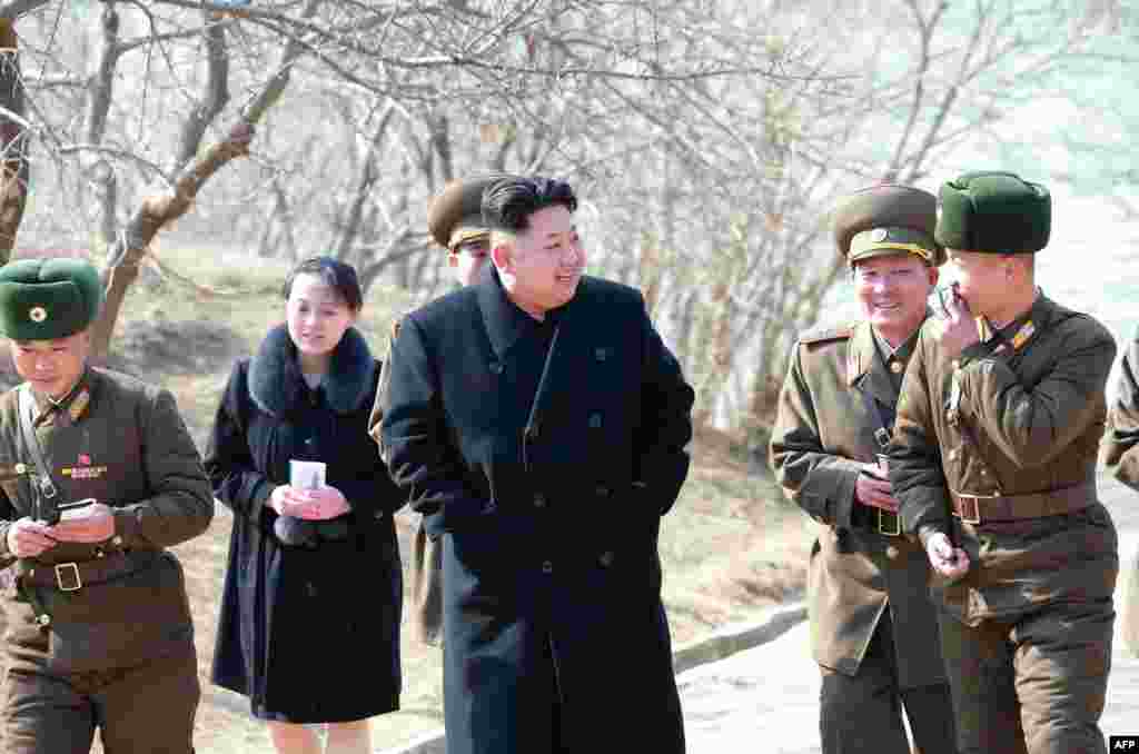 Esta imagen sin fecha publicada por la Agencia Central de Noticias de Corea del Norte (KCNA) el 12 de marzo de 2015 muestra al líder norcoreano Kim Jong-Un (C) inspeccionando la compañía de defensa Sin Islet en la provincia de Kangwon, en compañía de su h