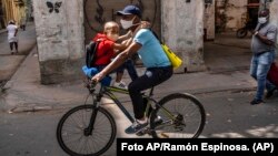 Un hombre transporta a un niño en bicicleta en La Habana. AP Photo/Ramon Espinosa