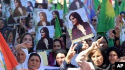 Imagen de mujeres protestando en Irán tras la muerte en custodia de la joven Mahsa Amini, quien fue arrestada el 16 de septiembre de 2022 por usar mal el velo. (Hawar News Agency via AP).